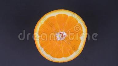 橙色在一个区域靠近。 明亮的橙色在黑色背景上旋转。 明亮的柑橘橘色